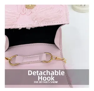 Detail of pink leather bag featuring detachable golden metal hooks and lace flower