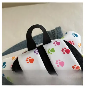 Close-up of durable black webbing handle on kid's backpack with colorful paw prints