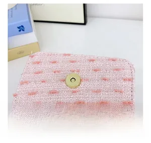 Detail of pink tweed bag featuring golden magnetic snap closure and soft lining