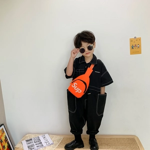 Tuta nera da bambino con borsa a tracolla arancione brillante e occhiali alla moda