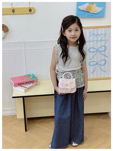 Mädchen hält rosa Tweed-Minitasche mit Spitzenschleife und elegantem Perlengriff