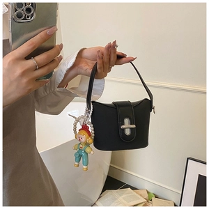 Detail of black mini bucket bag featuring silver twist lock and cute pearl charm