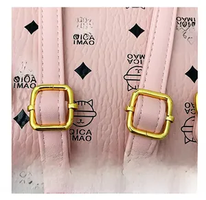 Detail of adjustable pink lychee leather straps with gold buckles and logo print