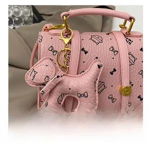 Détail du sac en cuir grainé rose avec charme de chien et fermoir en métal doré