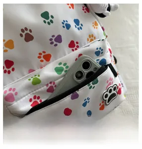 Close-up of the zippered front pocket showing the depth and colorful paw print pattern