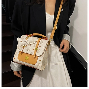 Detail of trendy quilted backpack with cute dog charm and golden clasp shown on model