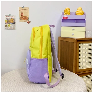 Detail of color-blocked school backpack side view featuring purple mesh pocket and nylon fabric