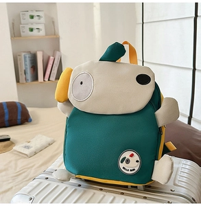 Süßer Hunde-Cartoon-Rucksack für Kinder auf einem weißen Koffer im Schlafzimmer