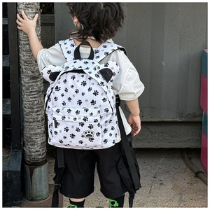 Close-up of cute cartoon backpack with black paw prints and decorative round ears
