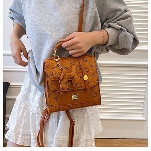 Détail du sac à dos style britannique avec imprimé chat et breloque en cuir assortie