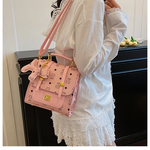 Detail of pink PU leather crossbody bag with cat monogram and horse charm