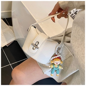 Detail of white woven bucket bag with smooth leather flap and cartoon pearl charm