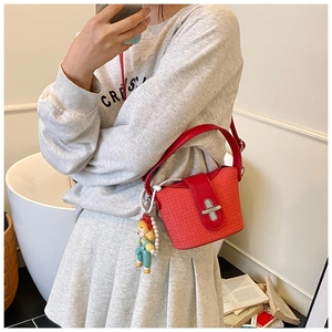 Red woven bucket bag with cute doll charm shown in mirror selfie for daily commute