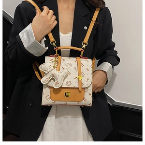 Détail du sac à dos crème avec imprimés chats et poche jaune avec fermoir doré chic