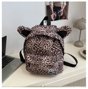 Detail of leopard print kids backpack featuring cute 3D ears and silicone paw patch