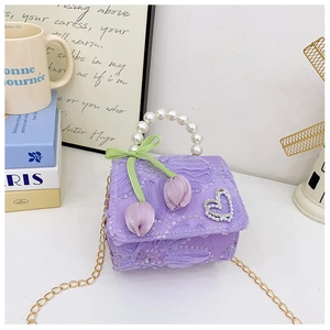 Detail of purple lace floral girl's bag with sequin fabric and heart pearl brooch