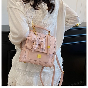 Pink quilted backpack with cat pattern and cute puppy charm on lace dress model