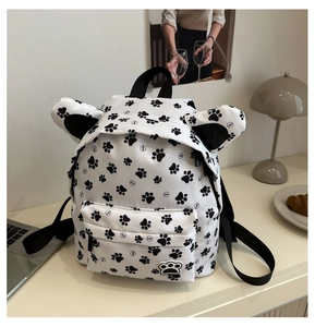 Detail showing the cartoon cat ear design and black paw prints on student backpack