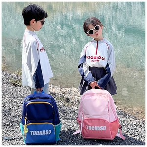 Outdoor shot of stylish contrast color kids backpacks in blue and pink with letter prints