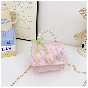 Detail of pink lace girls' mini bag with pearl handle and tulip floral bow decoration