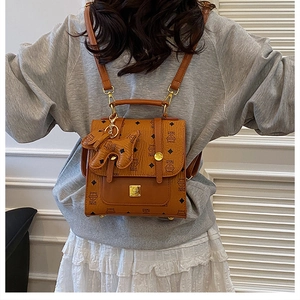 Brown faux leather mini backpack with animal print and cute dog charm shown on a model