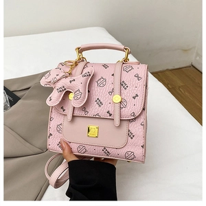 Détail du sac à dos rose à nœuds avec fermoir doré et pendentif chat mignon