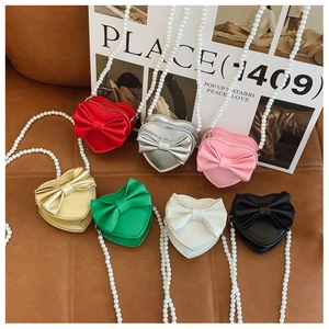 Detail of heart-shaped mini bags with bows and pearl straps in various colors