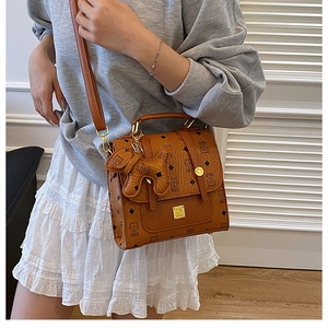 Caramel brown handbag with monogram cat pattern and cute puppy charm on grey hoodie