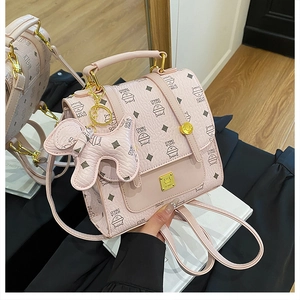 Detail of pink diamond pattern backpack with cute puppy charm and adjustable straps