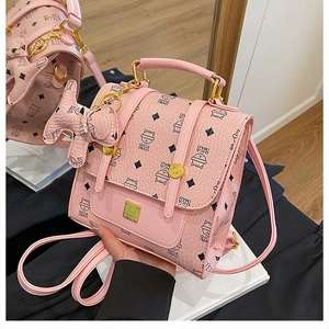Detail of pink faux leather backpack with cat print and cute puppy charm accessory