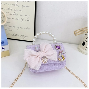 Detail of purple tweed mini bag with pearl handle, pink mesh bow and jeweled charms