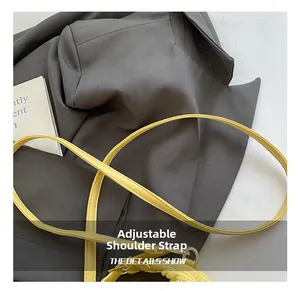 Details des verstellbaren Leder-Schultergurts mit Metallschnalle an der gelben Tasche