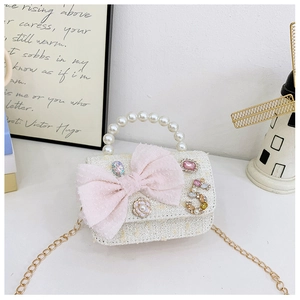 Close-up of white tweed kids bag with pink bow, pearl handle and gold chain