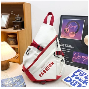 Detail view of a red and white crossbody chest bag with side mesh pocket and zip closure