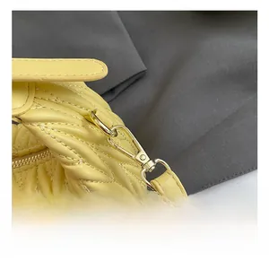 Detail der gelben Falten-Mädchentasche mit goldenem Metallhaken und ACIR-Markenaufnäher
