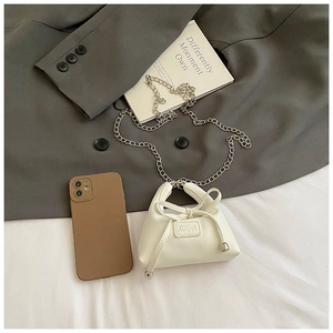 Size comparison of a white mini bow handbag next to a smartphone for perspective