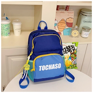 Detail of color-block school backpack with letter print and cartoon bear pendant