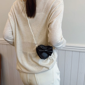 Cute heart-shaped girls crossbody bag with sweet bow and pearl chain in black leather