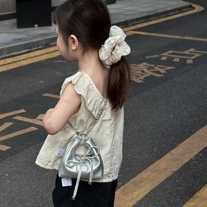 Silver mini crossbody bag for girls with bow detail and metal chain on a model