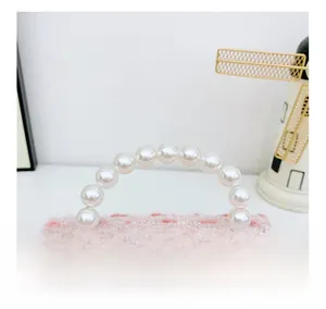 Detailed shot of pink sequin mesh bag featuring a beaded imitation pearl handle grip