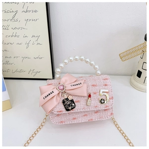 Pink tweed mini bag with pearl handle, satin bow and stylish metal charms detail
