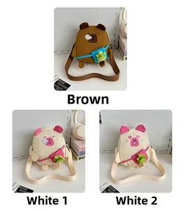 Détail des sacs bandoulière Capybara et cochon avec un petit porte-clé tortue