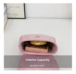 Vue macro du mini sac rose à motif crocodile montrant sa capacité intérieure et sa texture PU