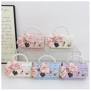 Detail view of mini tweed purses with pearl handles and decorative bow accents