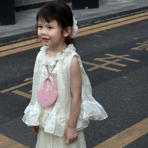 Vue détaillée d'un mini sac bandoulière rose en forme de cœur avec chaîne pour filles