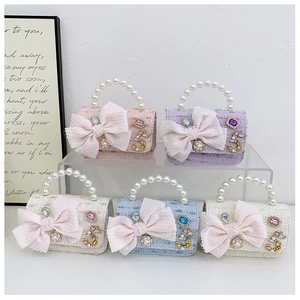 Detail of tweed mini bags with mesh bows, pearl handles, and rhinestone decorations