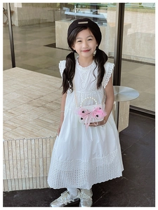 Close-up of white eyelet lace dress with pink bow pearl handle handbag for girls