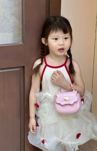 Sac à main rose pour filles avec texture crocodile porté par un enfant modèle