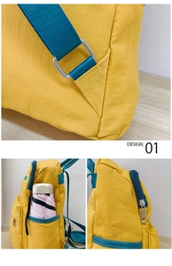 Detail view of yellow school bag showing side pocket, adjustable strap and metal zippers