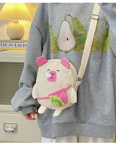 Détail du sac bandoulière cochon rose avec pendentif grenouille et sangle ajustable